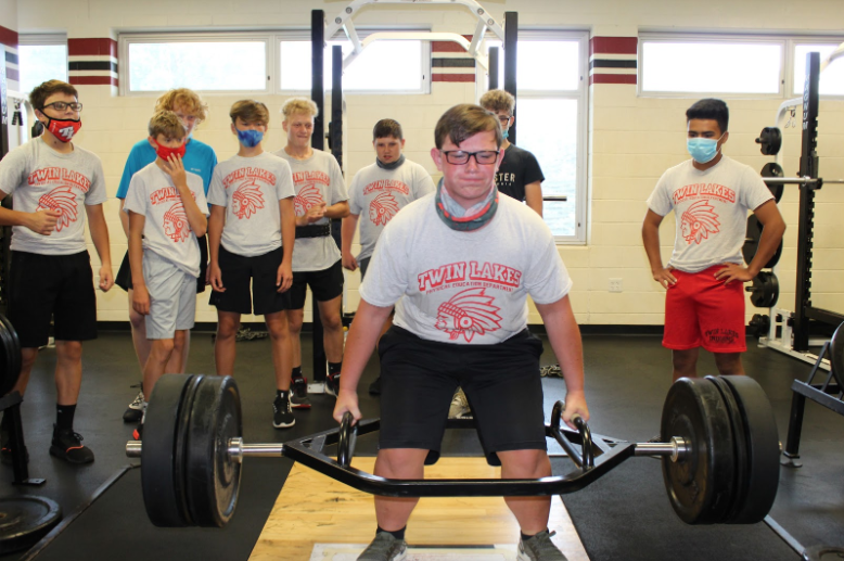 Eric+Fisher%2C+freshman%2C+lifting+weights+in+gym+class.+His+classmates+are+in+the+background+supporting+him+while+trying+to+lift+weights.+Eric+works+hard+to+get+stronger+everyday.%0A