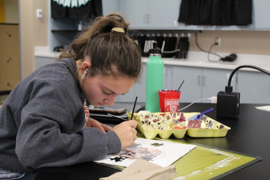 A student in Mrs. Padlos art class works on her unique painting.