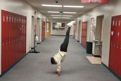 Senior Sinai Aguilar takes a much needed mental break and decides to practice her love for handstands while on her way back to class.