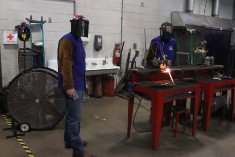 Alex Harker and Brady Schroeder use a cutting torch while completing a project in their second year welding class.